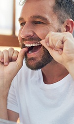Man flossing his teeth